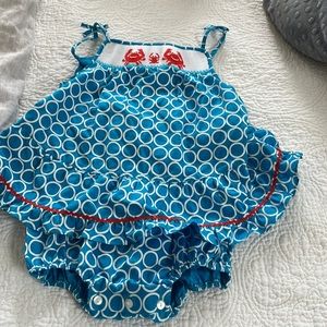 One piece. Buttons at diaper bottom. Roomy suit.